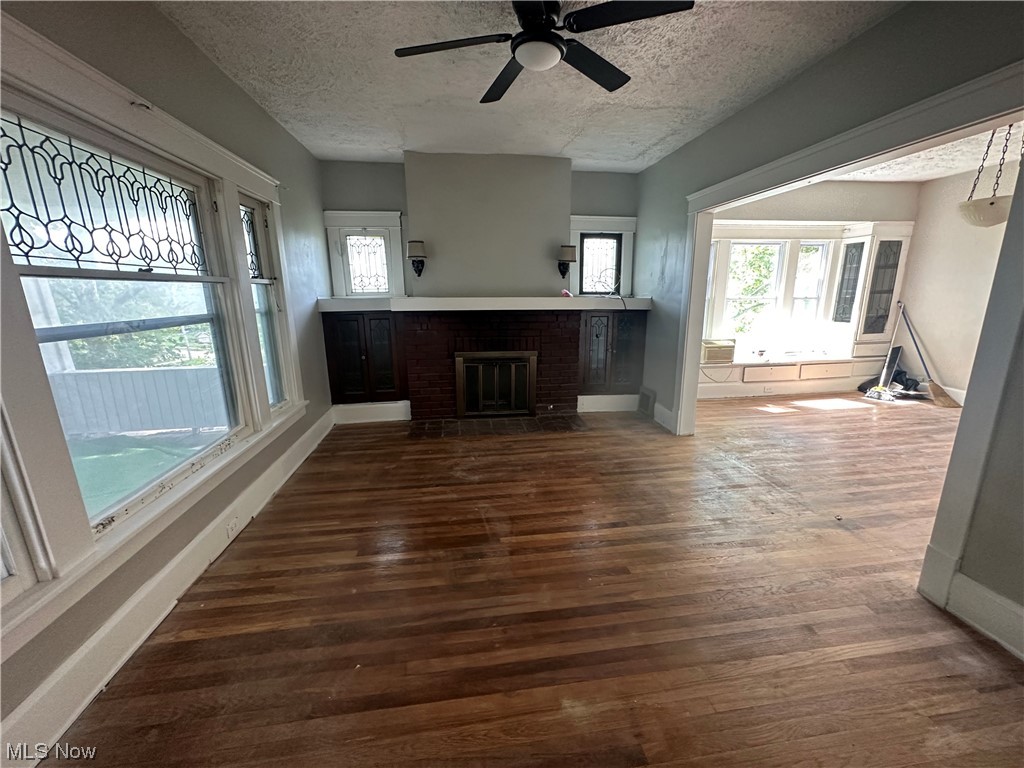 10820 Bellaire Road Cleveland, OH 44111 - Photo 6 of 24 Hardwood floored living room with a textured ceiling, a fireplace, and ceiling fan