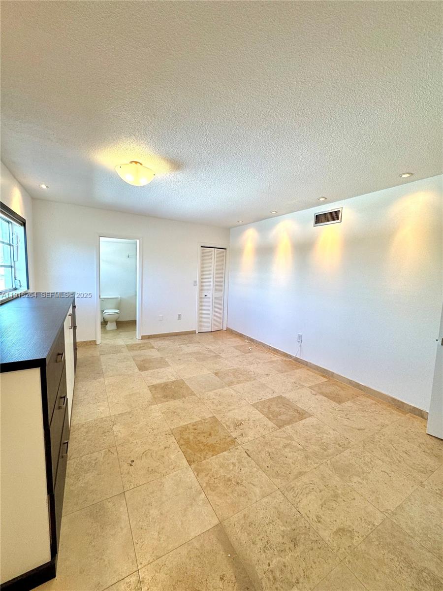 1020 94th Street, Unit 402 Bay Harbor Islands, FL 33154 - Photo 11 of 15 a view of an empty room with window and a kitchen