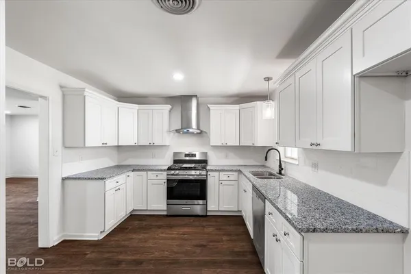 a kitchen with stainless steel appliances granite countertop a sink stove and cabinets