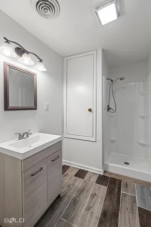 a bathroom with a shower sink and mirror