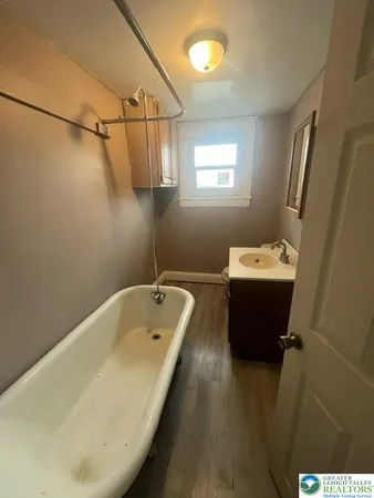 a bathroom with a tub sink and mirror