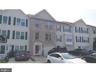 a front view of a building with lot of cars parked on road