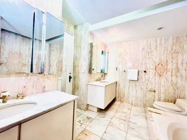 a spacious bathroom with a double vanity sink a mirror and a bathtub
