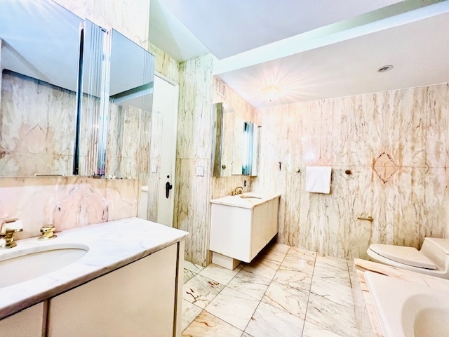 530 East 76th Street, Unit 35H36H Manhattan, NY 10021 - Photo 11 of 16 a spacious bathroom with a double vanity sink a mirror and a bathtub