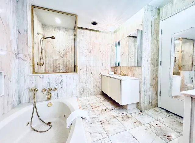 a bathroom with a tub sink and mirror