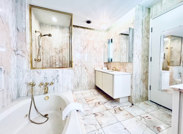 530 East 76th Street, Unit 35H36H Manhattan, NY 10021 - Photo 12 of 16 a bathroom with a tub sink and mirror
