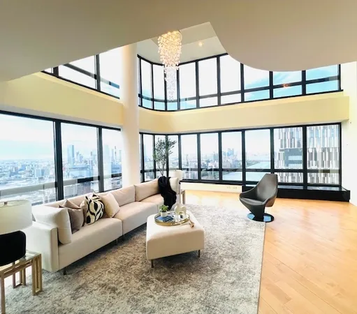 a living room with furniture floor to ceiling window and a flat screen tv