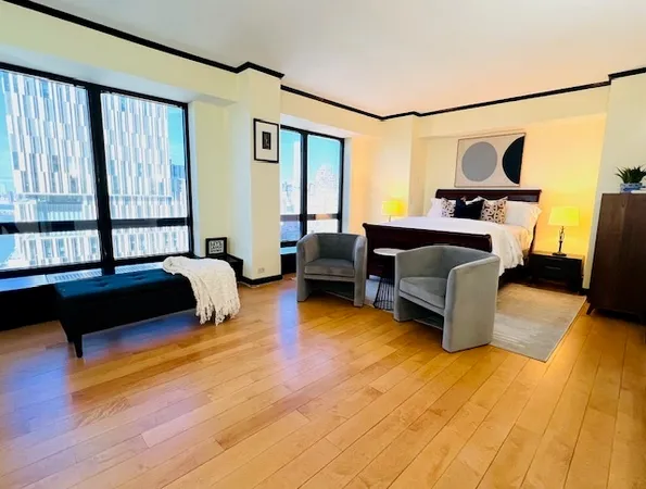 a bedroom with furniture and a large window