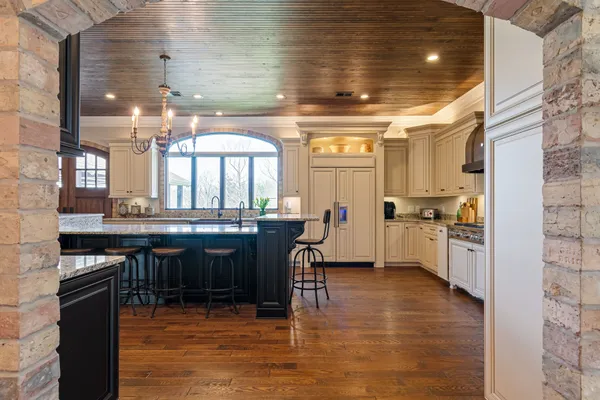 a kitchen with stainless steel appliances granite countertop a sink a stove and a wooden cabinets