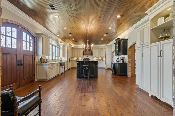 a kitchen with stainless steel appliances granite countertop a sink a stove and a wooden floors