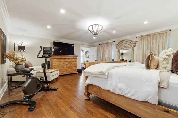 a bathroom with a tub a sink and a large window with wooden floor