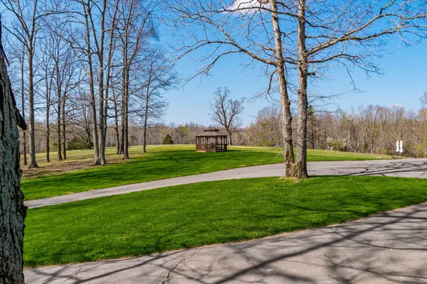 a backyard of a house with lots of green space and fountain