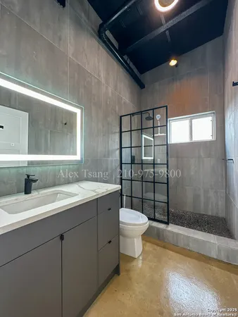 a bathroom with a bathtub shower sink mirror vanity and toilet