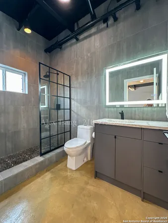 a bathroom with a granite countertop sink toilet and shower