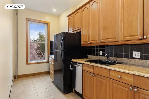 a kitchen with stainless steel appliances granite countertop a refrigerator and a sink