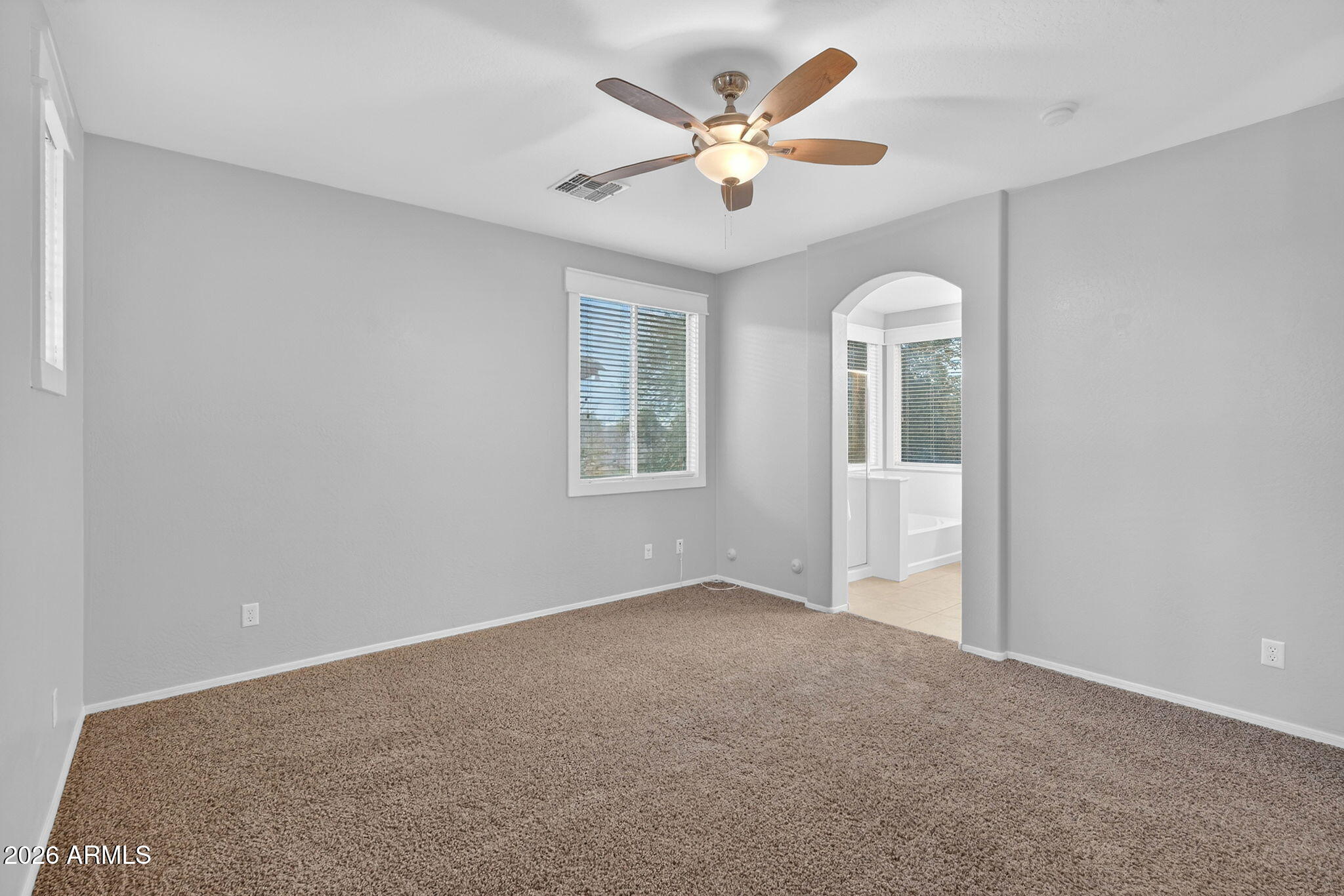 4052 East Milky Way Gilbert, AZ 85295 - Photo 24 of 73 an empty room with a chandelier fan and windows