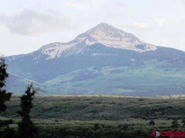 a view of a house with a mountain and a forest