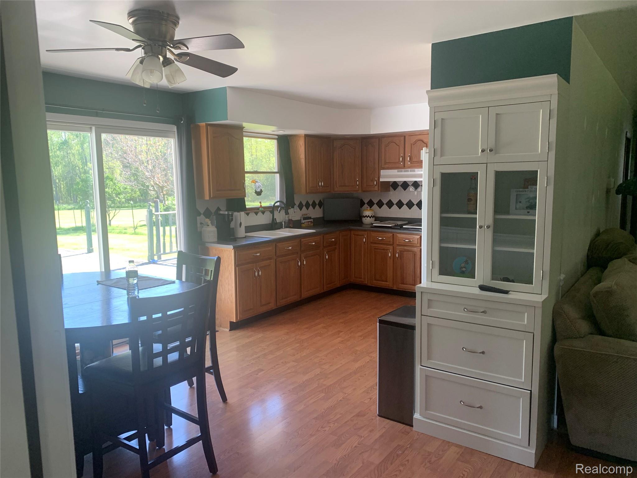 3494 Castle Road North Branch, MI 48461 - Photo 5 of 22 Kitchen with wood-finish flooring, light wood cabinetry, and a black and white diamond-patterned backsplash