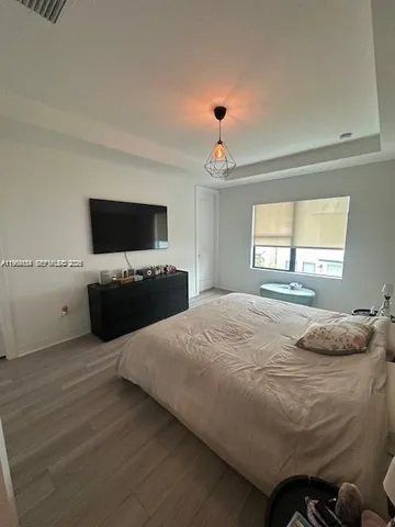 a bedroom with a bed and a flat screen tv