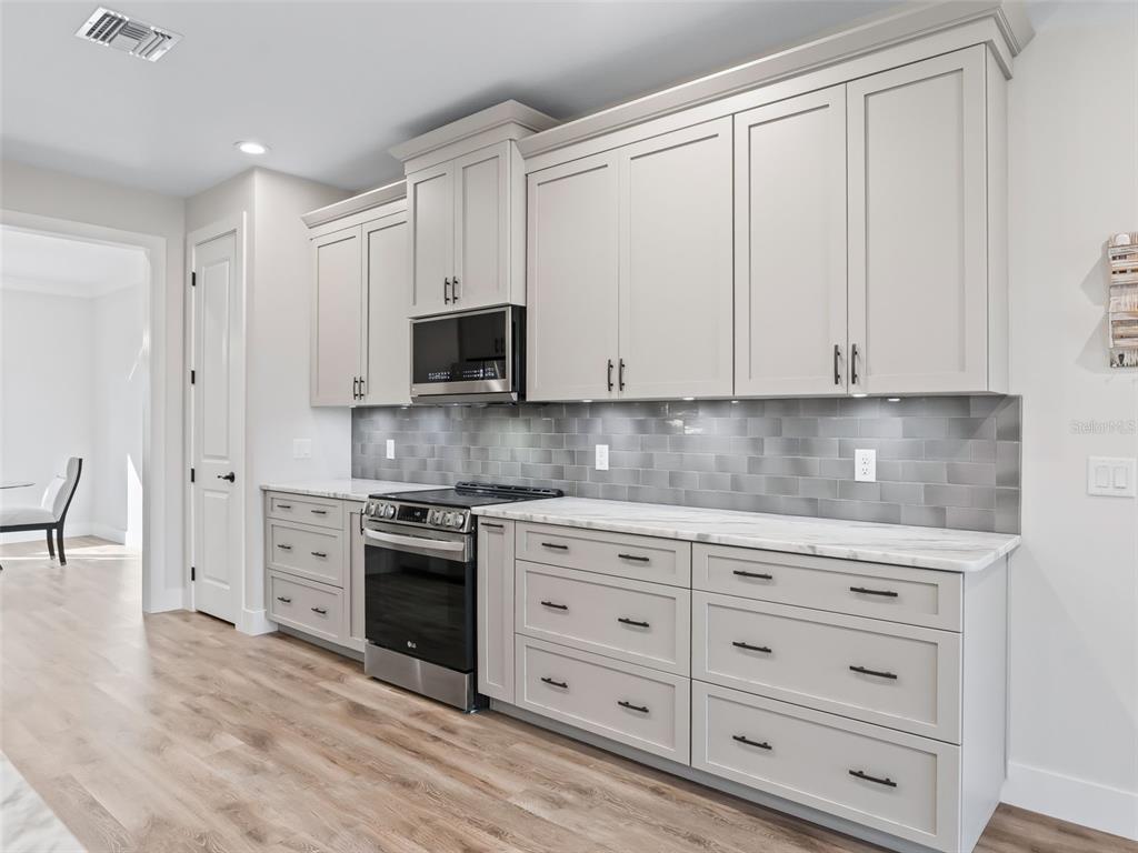 562 Dowling Circle Lady Lake, FL 32159 - Photo 14 of 62 a kitchen with granite countertop white cabinets and stainless steel appliances