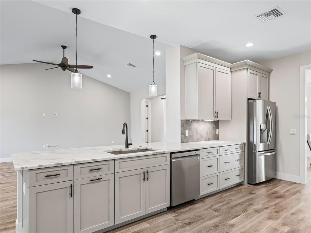562 Dowling Circle Lady Lake, FL 32159 - Photo 16 of 62 a kitchen with a sink stainless steel appliances and cabinets