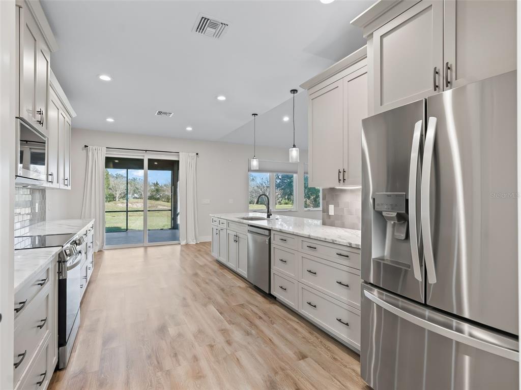 562 Dowling Circle Lady Lake, FL 32159 - Photo 19 of 62 a kitchen with stainless steel appliances a refrigerator sink and cabinets