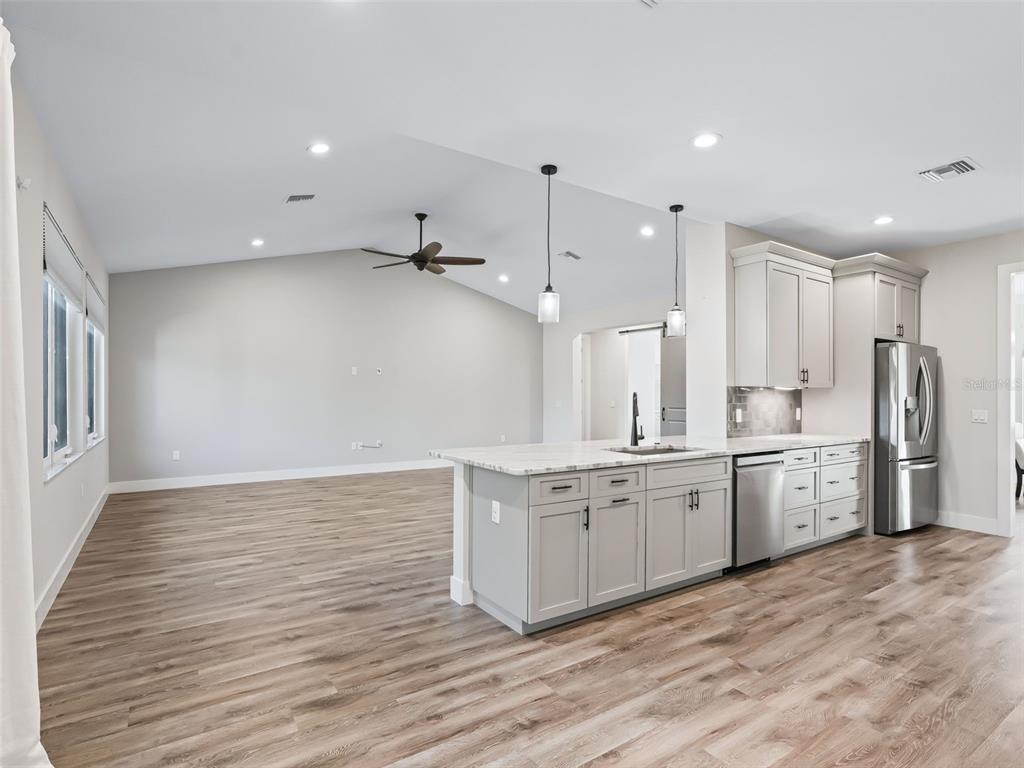 562 Dowling Circle Lady Lake, FL 32159 - Photo 21 of 62 a large kitchen with granite countertop a large counter top a sink stainless steel appliances and cabinets