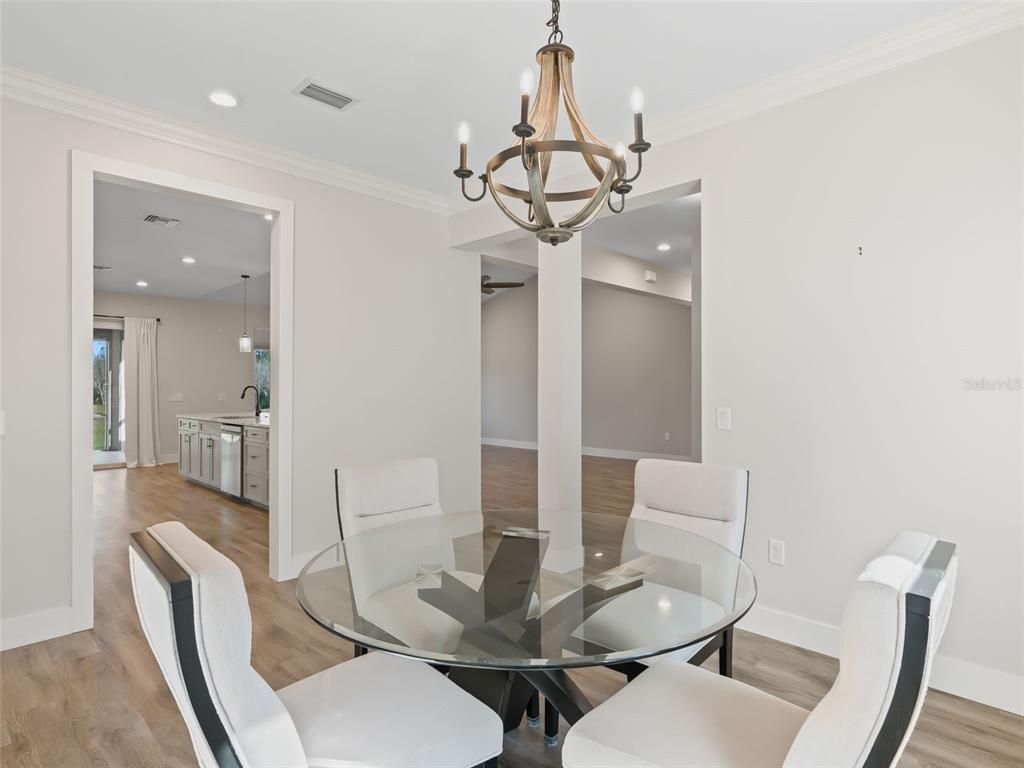 562 Dowling Circle Lady Lake, FL 32159 - Photo 23 of 62 a view of a dining room with furniture wooden floor and chandelier