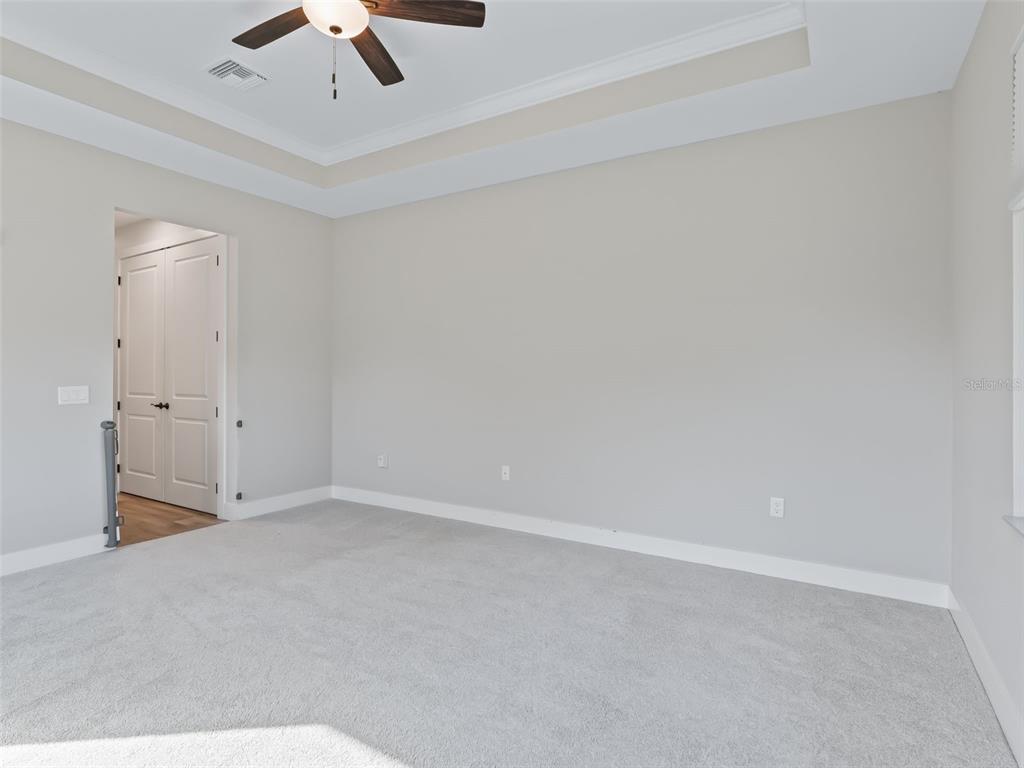 562 Dowling Circle Lady Lake, FL 32159 - Photo 29 of 62 an empty room with a ceiling fan and carpet