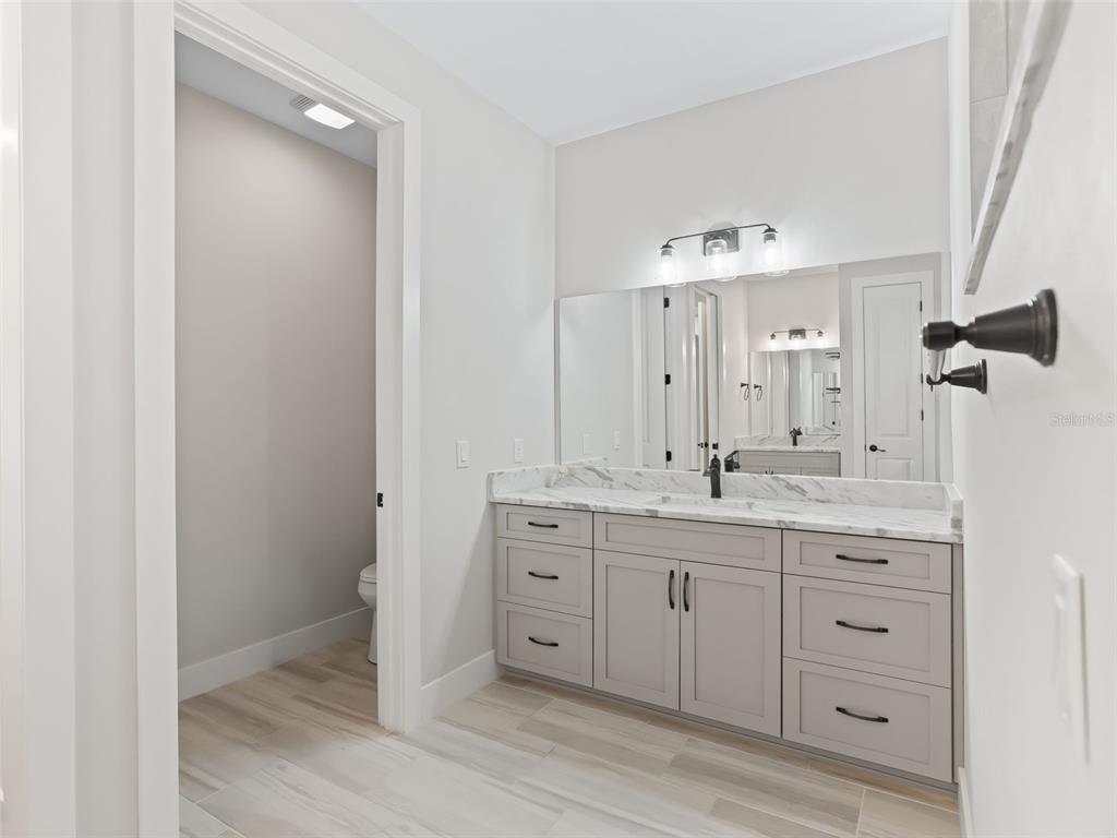 562 Dowling Circle Lady Lake, FL 32159 - Photo 33 of 62 a bathroom with a granite countertop sink double and mirror