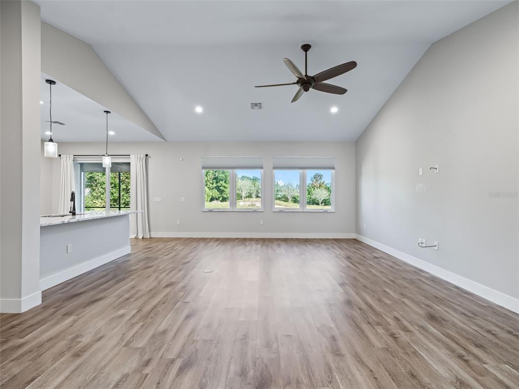 562 Dowling Circle Lady Lake, FL 32159 - Photo 8 of 62 wooden floor in an empty room with a window