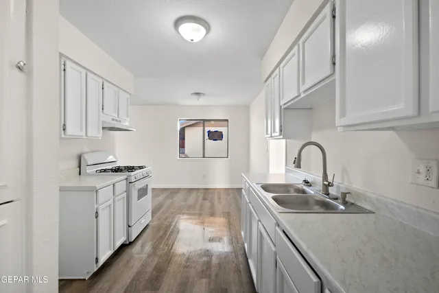 a kitchen with stainless steel appliances granite countertop a sink stove and cabinets