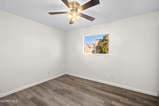 an empty room with a window and a fan