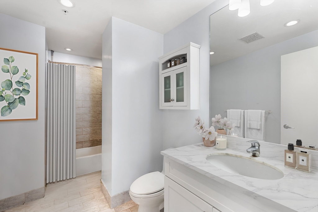 181 Essex Street, Unit E402 Boston, MA 02111 - Photo 5 of 10 a bathroom with a sink toilet and shower