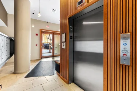 a view of a hallway with a cabinet and a bathroom