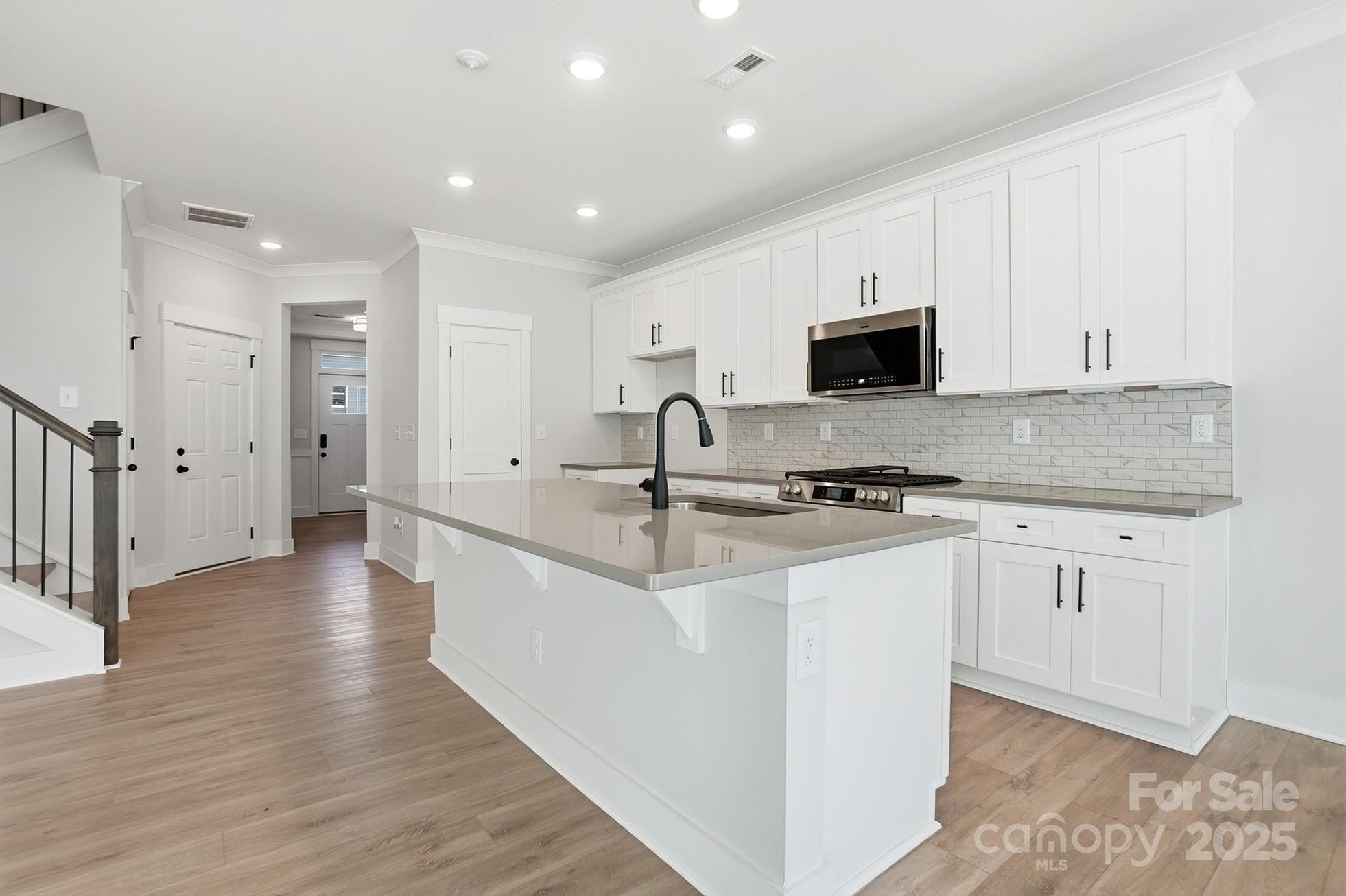 111 Viburnum Road Waxhaw, NC 28173 - Photo 11 of 39 a kitchen with stainless steel appliances granite countertop a sink stove and cabinets