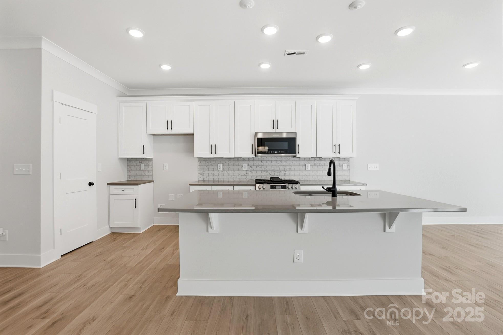111 Viburnum Road Waxhaw, NC 28173 - Photo 9 of 39 a large kitchen with stainless steel appliances granite countertop a stove a sink a refrigerator and white cabinets