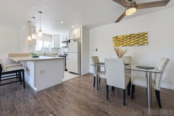 a kitchen with kitchen island a dining table chairs stainless steel appliances and cabinets
