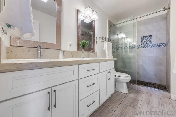 a bathroom with a sink a toilet and a mirror