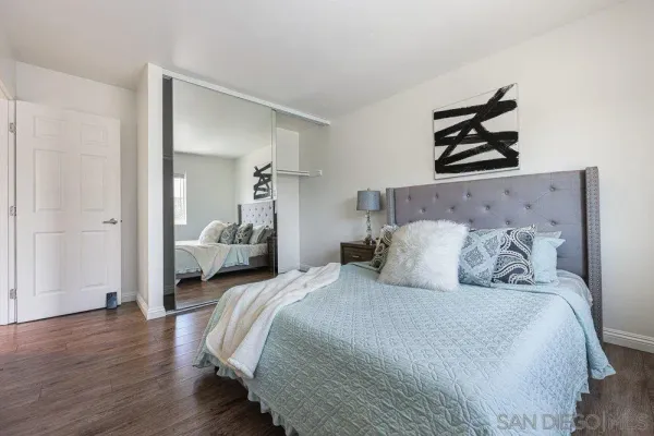 a bedroom with a bed and wooden floor