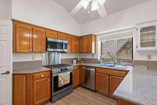 a kitchen with stainless steel appliances granite countertop a sink stove and cabinets