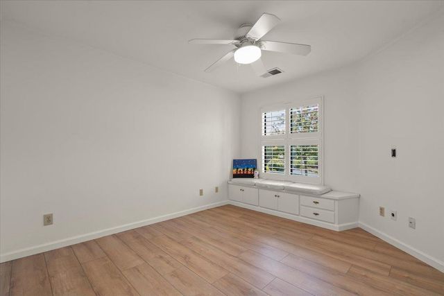 an empty room with wooden floor and window