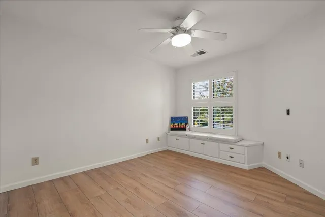 an empty room with wooden floor and window