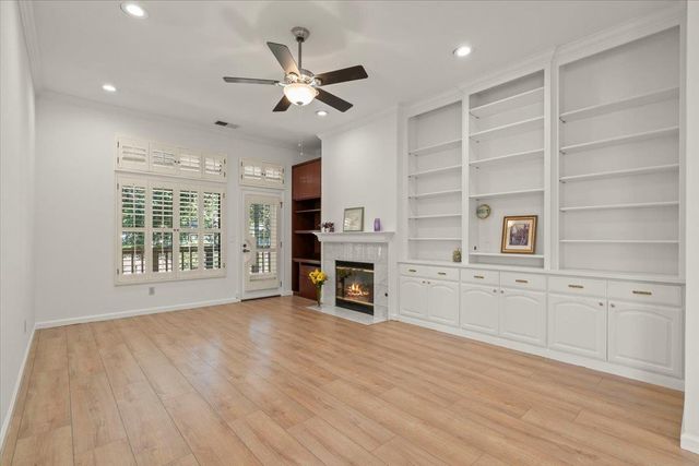 a view of an empty room with a window and fireplace