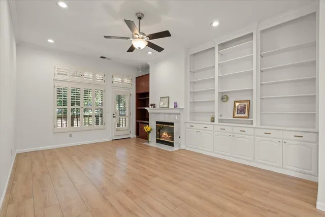a view of an empty room with a window and fireplace