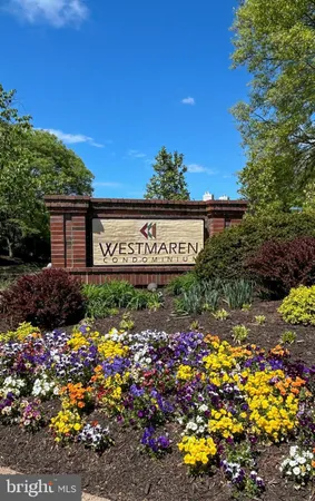 a view of a sign board with buildings in the background