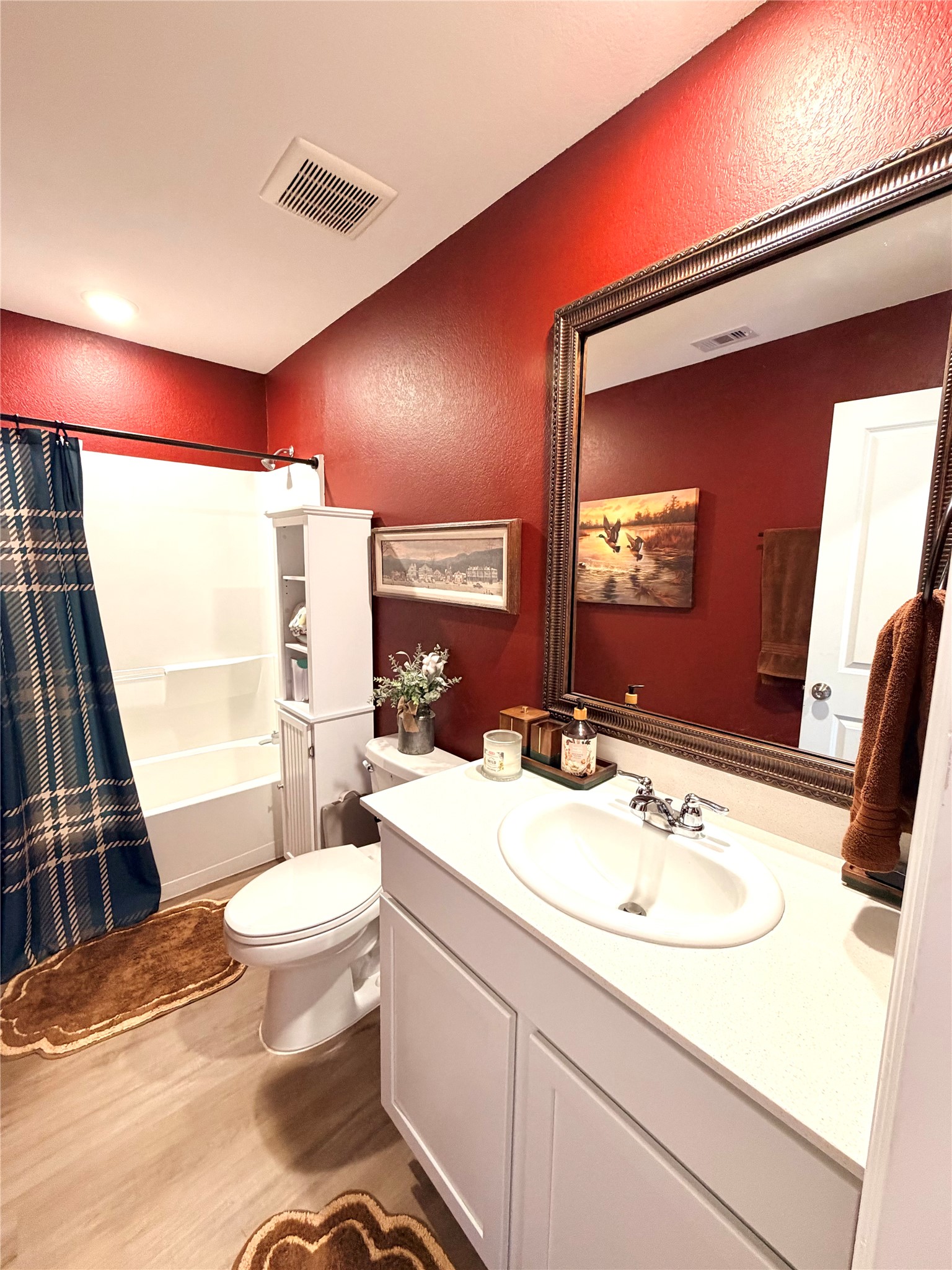 532 Flower Reed Court Magnolia, TX 77354 - Photo 26 of 43 This bathroom features warm walls and a modern design with a white vanity and sink. It includes a shower-tub combo, a large mirror, and ample storage space!