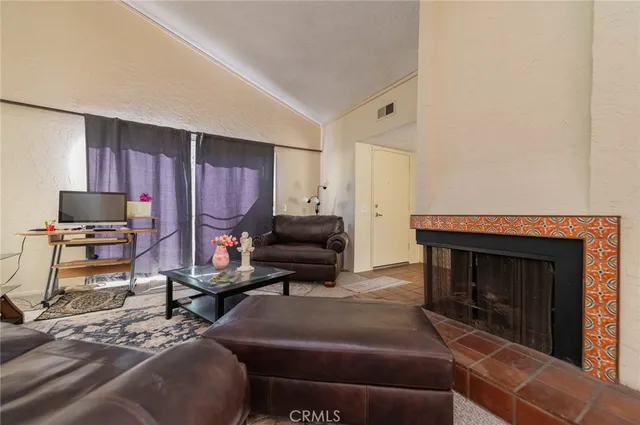 a living room with furniture a fireplace and a flat screen tv