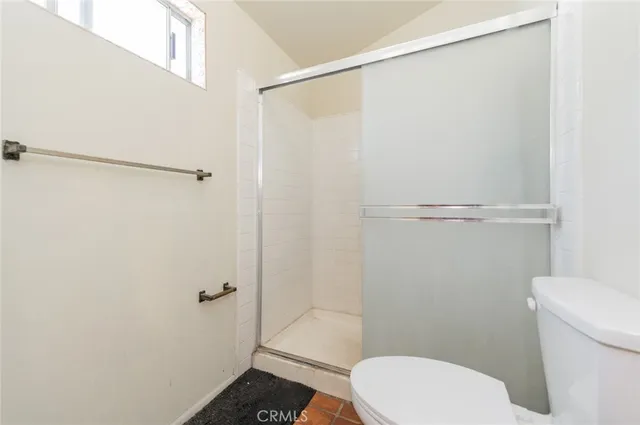 a white toilet sitting next to a shower