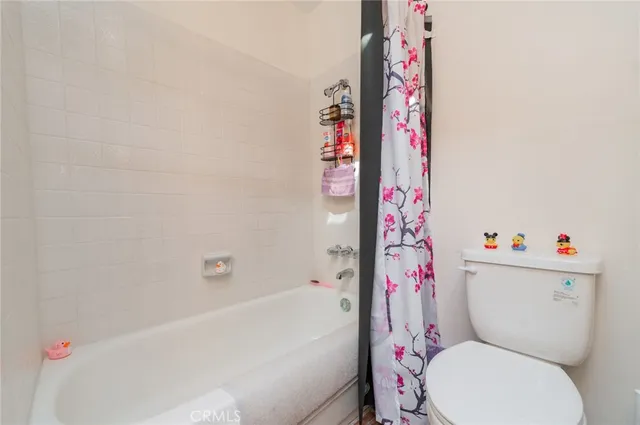 a white toilet sitting next to a bath tub